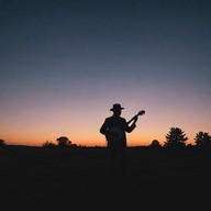 banjo plays under a pink sky.